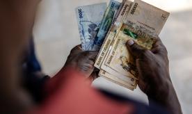 A man working for a forex bureau displays some Ugandan shilling notes
