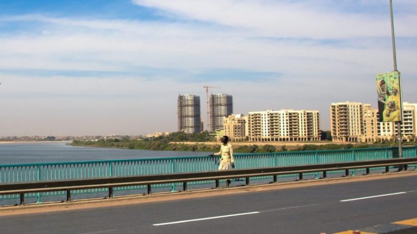 Sudanese man crossing bridge